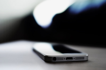 Track a cell phone in Milwaukee, WI iPhone on desk with tilt shift effect